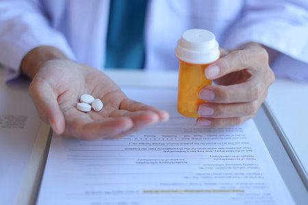 Prescription in hand. Pharmacist, Doctor or General practitioner explain to patient how to use prescribed medicine correctly by explain dosage, frequency, and timing.の写真素材