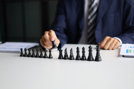 Businessman wearing suit, playing chess game. Business strategy, leadership, planning and management concept.の写真素材