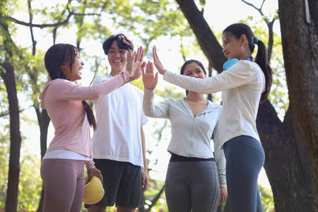 Group of friends putting hand to gather. Teamwork, celebration or success concept.の写真素材