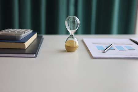 Sand clock on office desk. Concept for counting down and time management.