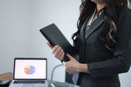 Businesswoman working in office, holding folder.