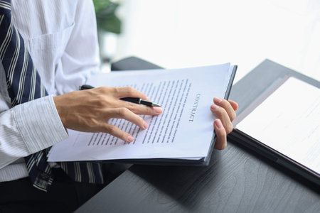 Male executive singing legal documents for a corporate partnership at desk.