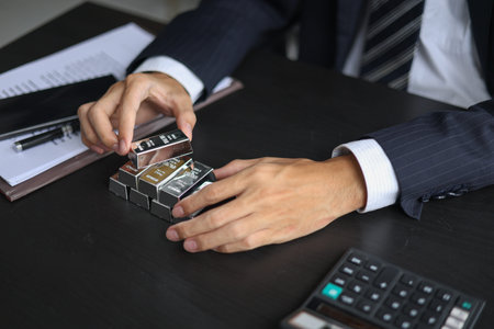 Stacked Silver Bars on the table with businessman managing his precious metals portfolio in office...