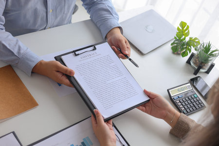 Businessman Handing Over Contract and Pen for Signature in Workplace.