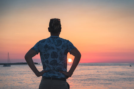 Blond man relaxing at the seaside at summer sunrise.