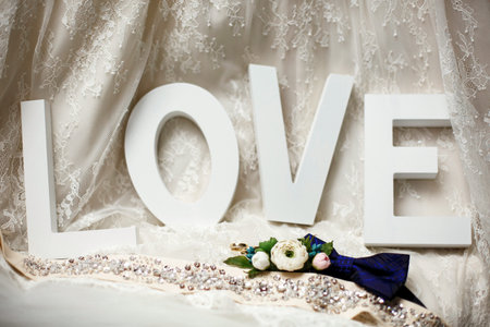 Wedding rings lie in front of the word Love. Decor