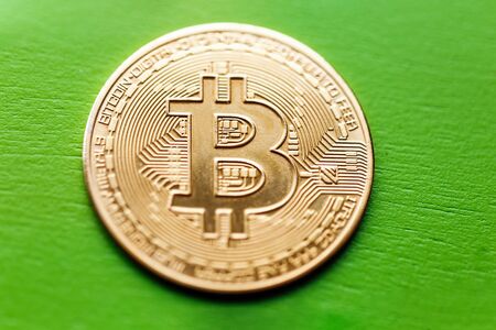 Bitcoin gold coin on a green wooden background.の写真素材