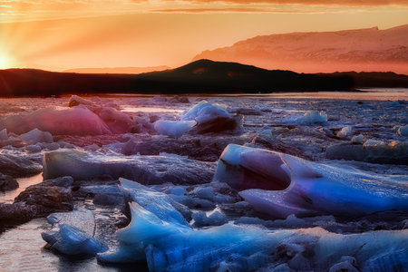 sunset in a glacial lagoon under the iceberg