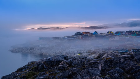 an evening mist hovering over the Greenlandic city of Ilulissat