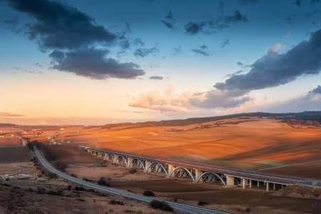 Gray Chin Chapel at sunset with an interesting highway bridge in the backgroundの写真素材