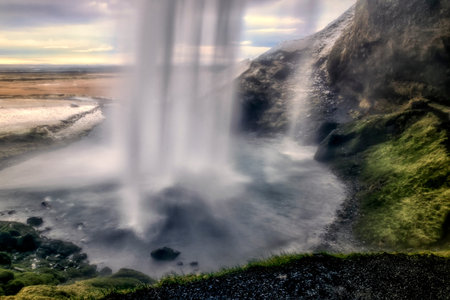 Seljalandsfoss an impressive cascade, majestic waterfall seen from a cave behind