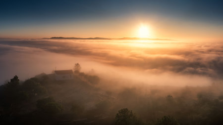 Hilltop house in mist at sunriseの写真素材