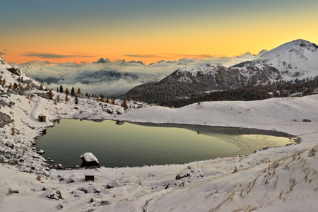 lake in the Dolomites Lago di Valparola with snow in autumn with reflectionの写真素材