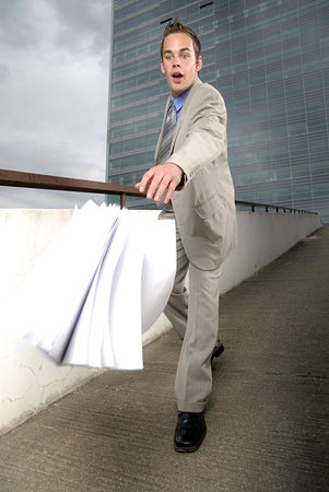Bad day - fumbler businessman with mobile phone in front of modern business building. 