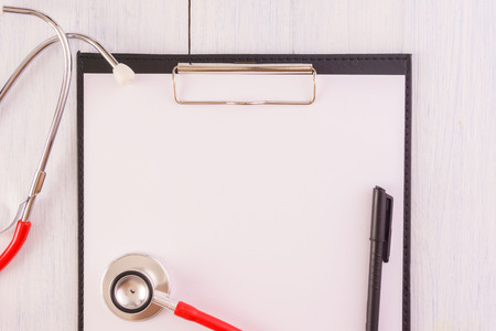 Stethoscope,note pad,pen on wooden desk as medical conceptの写真素材