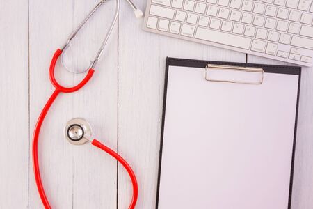 Stethoscope,note pad on wooden desk as medical conceptの写真素材