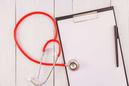 Stethoscope,note pad,pen on wooden desk as medical conceptの写真素材