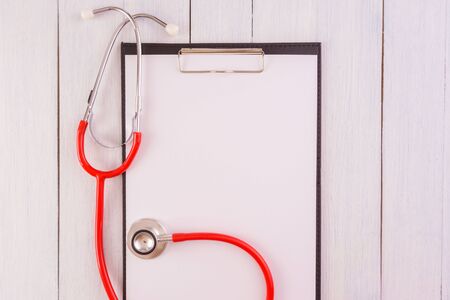 Stethoscope,note pad on wooden desk as medical conceptの写真素材