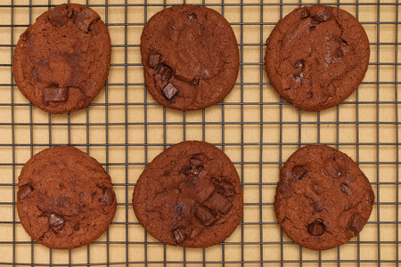 Flat lay of homemade sweets, Chocolate cookies on rack with wooden tray on wood background.の写真素材