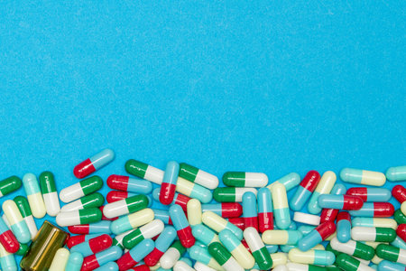 Pharmaceutical and health concept, Variety of antibiotic capsules on light blue background.