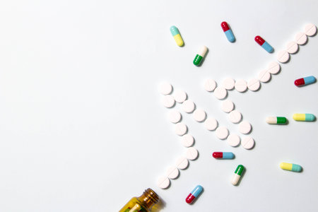 Pharmaceutical and health concept, Tablets spilled out from brown bottle into in heart wave shape.の写真素材