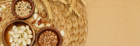 Flat lay of healthy grain concept, Pistachios and bean in wooden bowl and wheat on brown background.