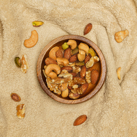Flat lay of healthy grains concept, Nuts and almond in wooden bowl on wool blanket.の写真素材