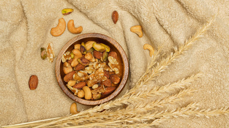 Flat lay of healthy grains concept, Nuts and almond in wooden bowl and wheat on wool blanket.の写真素材