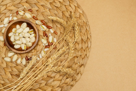Flat lay of healthy grains concept, Pistachios in wooden bowl beans and wheat on brown background.の写真素材