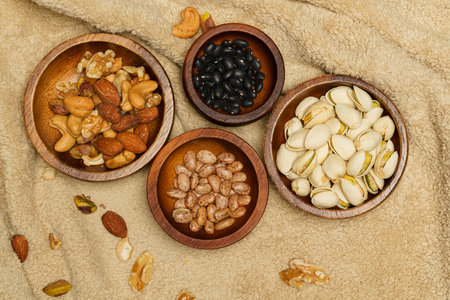 Flat lay of healthy grains concept, Pistachios almond and beans in wooden bowl on wool blanket.の写真素材