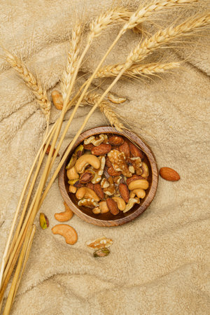 Flat lay of healthy grains concept, Nuts and almond in wooden bowl and wheat on wool blanket.の写真素材