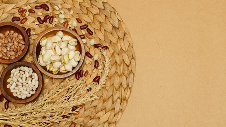 Flat lay of healthy grain concept, Pistachios and bean in wooden bowl and wheat on brown background.の写真素材