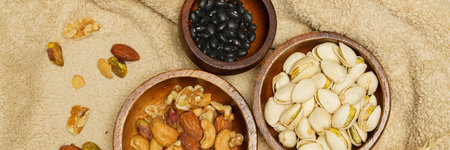 Flat lay of healthy grains concept, Pistachios almond and beans in wooden bowl on wool blanket.の写真素材