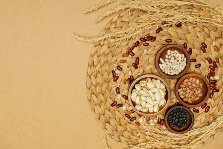 Flat lay of healthy grain concept, Various beans in wooden bowl and wheat on brown background.の写真素材