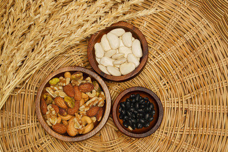 Flat lay of healthy grains concept, Various beans and almond in wooden bowl and wheat on basket.の写真素材