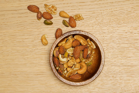 Flat lay of healthy grain concept, Nut and almond in wooden bowl on wood table.の写真素材
