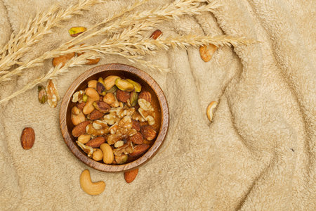 Flat lay of healthy grains concept, Nuts and almond in wooden bowl and wheat on wool blanket.の写真素材