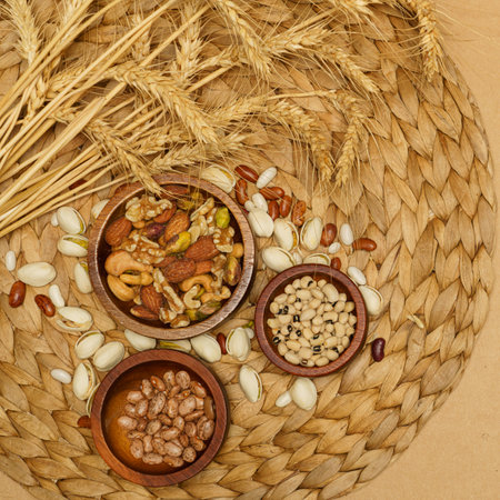 Flat lay of healthy grains concept, Beans in wooden bowl pistachios and wheat on brown background.の写真素材