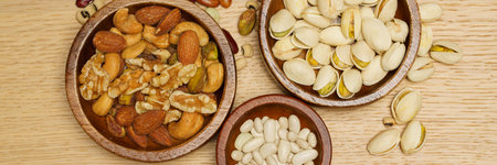 Flat lay of healthy grain concept, Pistachios and almond in wooden bowl and beans on wood table.の写真素材