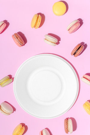 French dessert concept, Colorful macarons in pastel tones and white plate on pink background.の写真素材