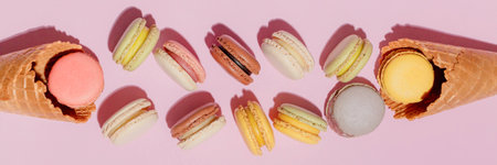 French dessert concept, Colorful macarons are served in waffle cone and falling on pink background.の写真素材
