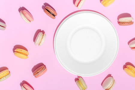 French dessert concept, Colorful macarons in pastel tones and white plate on pink background.の写真素材