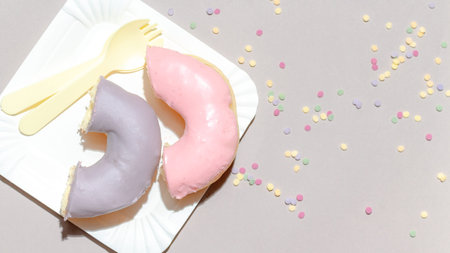 Sweet dessert concept, Colorful pastel donuts in white plate with cutlery on grey background.の写真素材