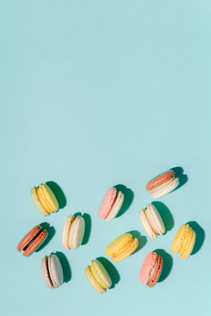 French dessert concept, Arrangement of colorful pastel macarons on light blue background.の写真素材