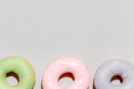Sweet dessert concept, Arrangement in row of delicious pastel donut on grey background.の写真素材