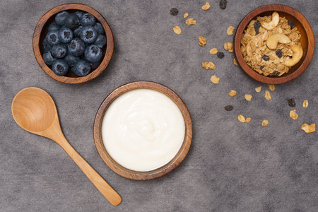Healthy lifestyle concept, Greek yogurt fresh blueberry and granola in wood bowl on grey background.の写真素材