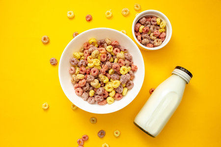 Healthy breakfast concept, Colorful ring cereals in large bowl and mini bowl with milk in bottle.の写真素材