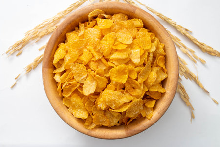 Healthy food concept, Cornflakes in wooden bowl with wheat on white background.