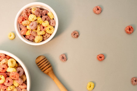 Breakfast cereal concept, Colorful ring cereals in bowl and falling on grey background.の写真素材
