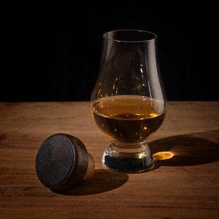 Whiskey glass and cork on wooden tableの写真素材